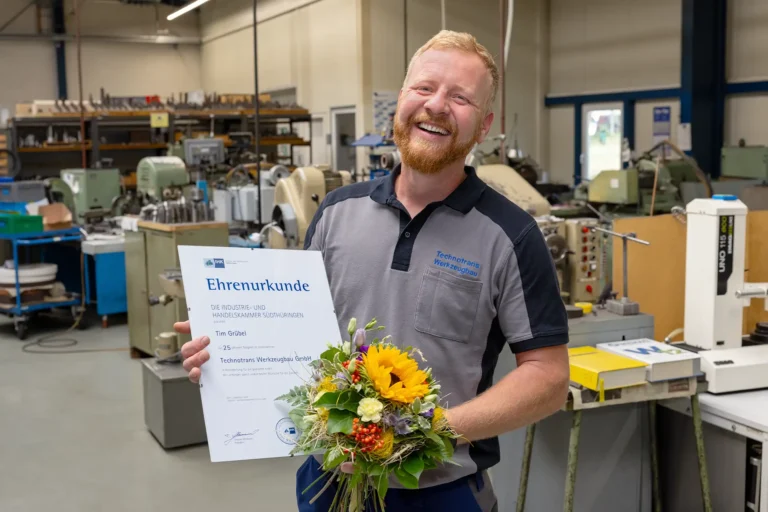 Tim Grübel hält lachend seine Ehrenurkunde